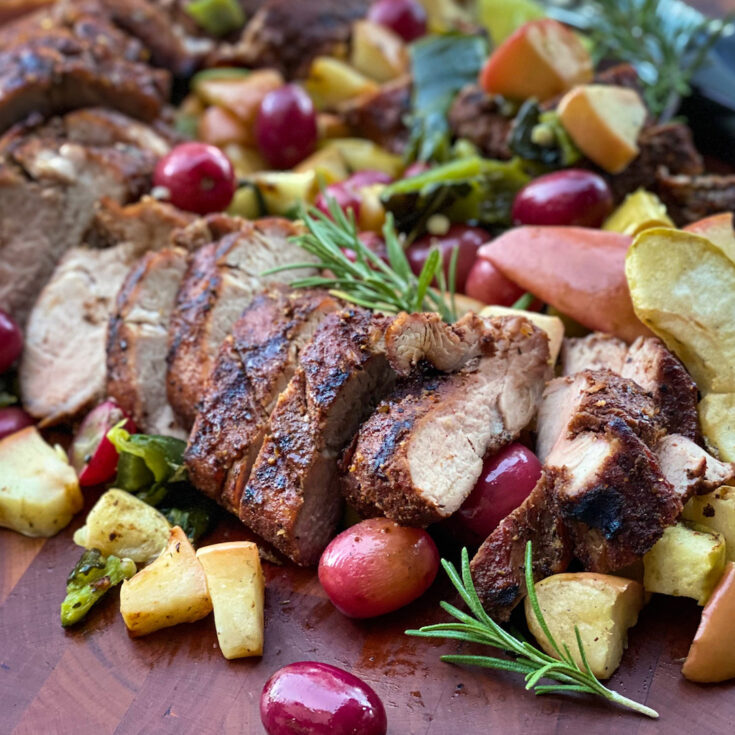 Close up of Smoked Pork Tenderloin with smoked and roasted grapes, apples, and poblano pepper.