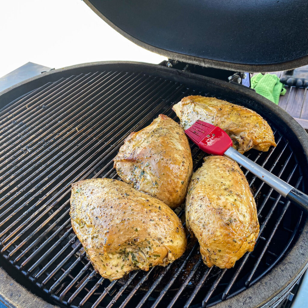 Chicken Breasts on a grill smoke before charring. 