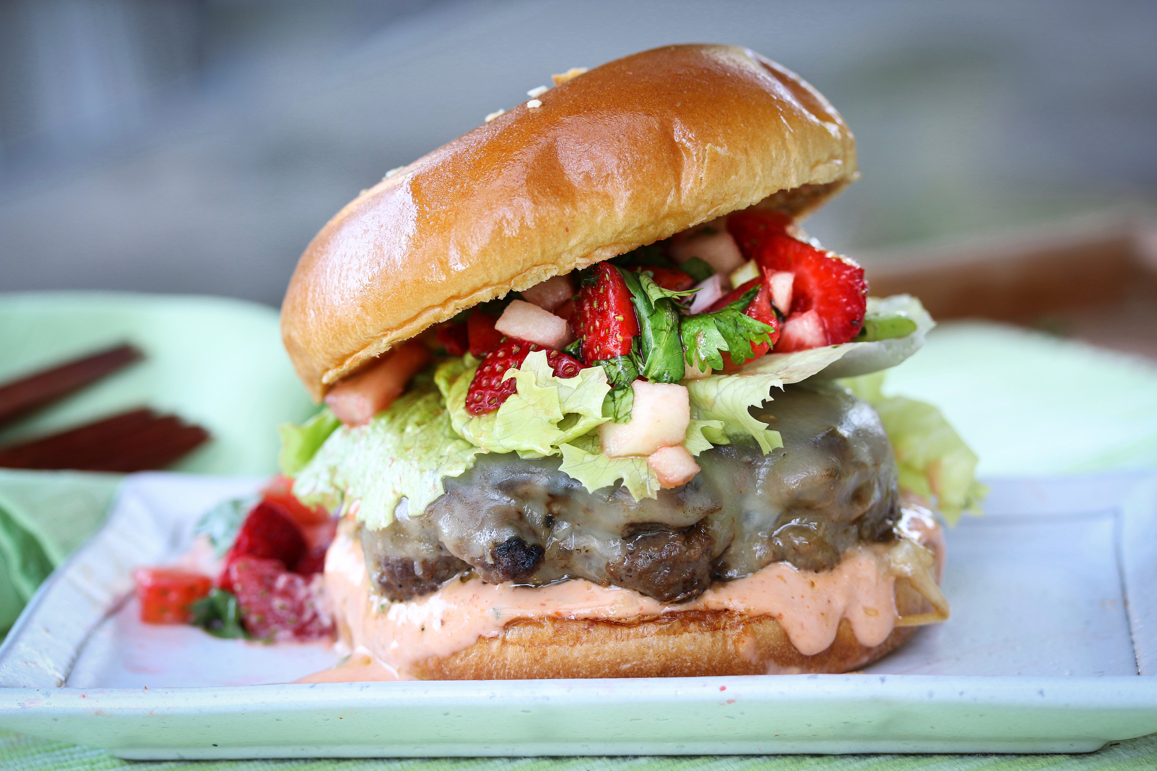 A beautiful strawberry relish beef burger on a brioche bun. 