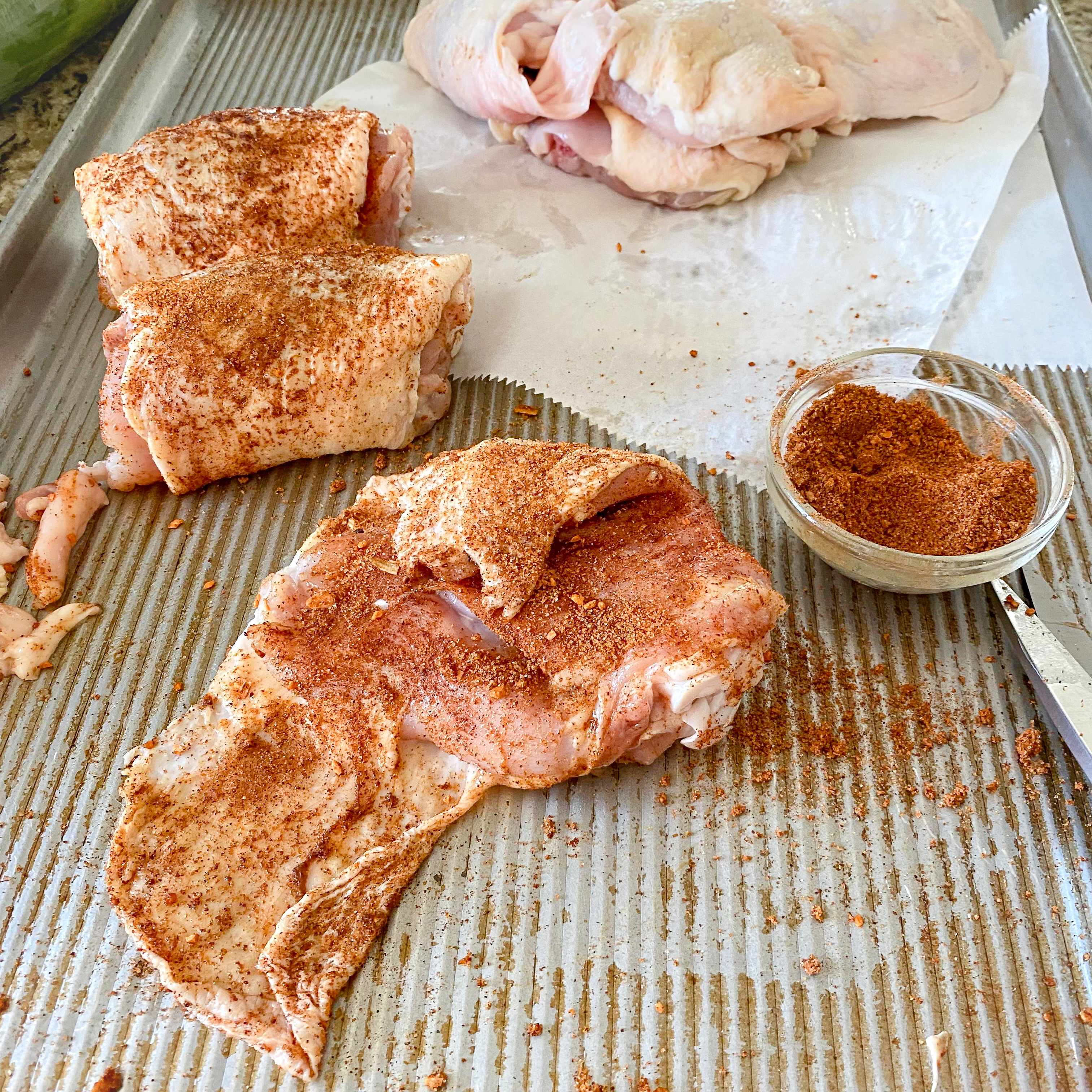 Lay chicken thigh, skin side down. Stretch any extra skin and season. 