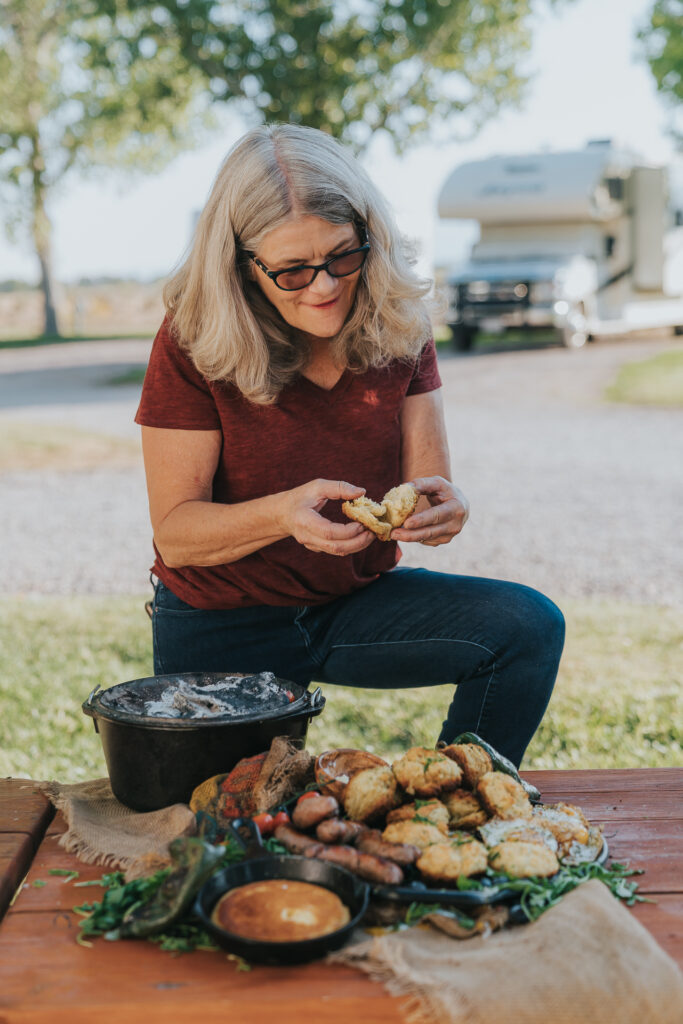 Grilling Grandma breaks open a homemade Dutch Oven biscuit baked in a fire pit. 