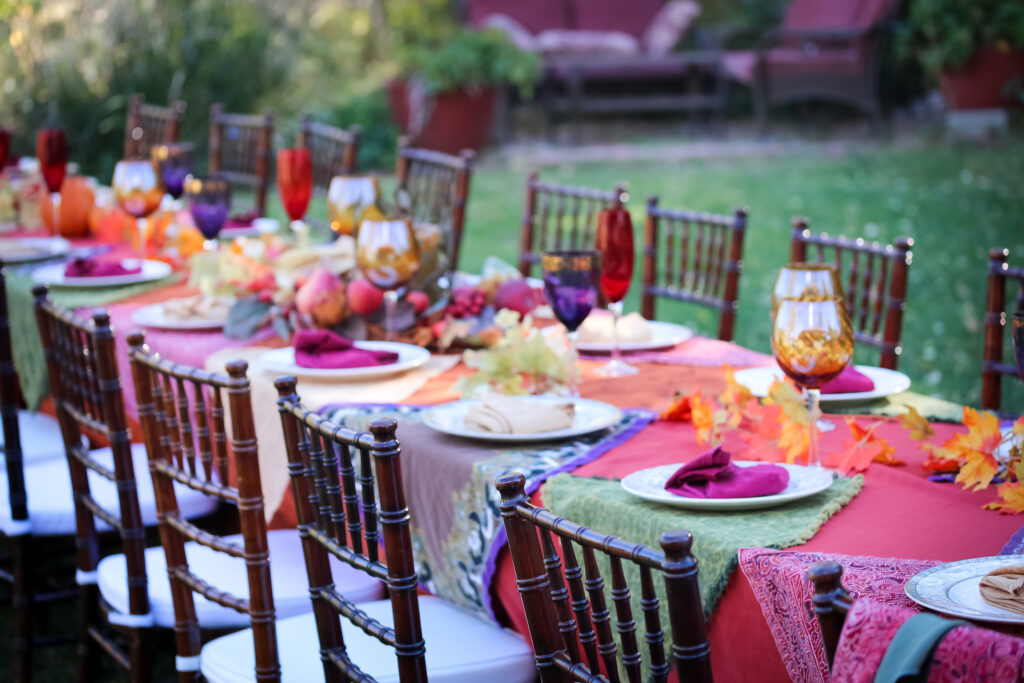 A Thanksgiving table is set with festive colors. 