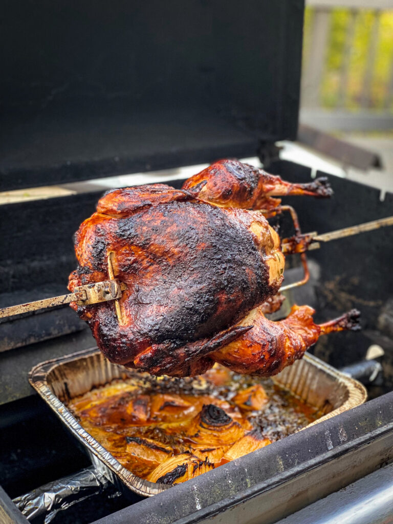 A turkey has just fiished cooking on the rotiserrie grill.