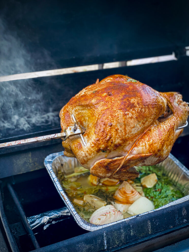 A seasoned turkey has cook for 30 minutes on the rotiserrie grill.