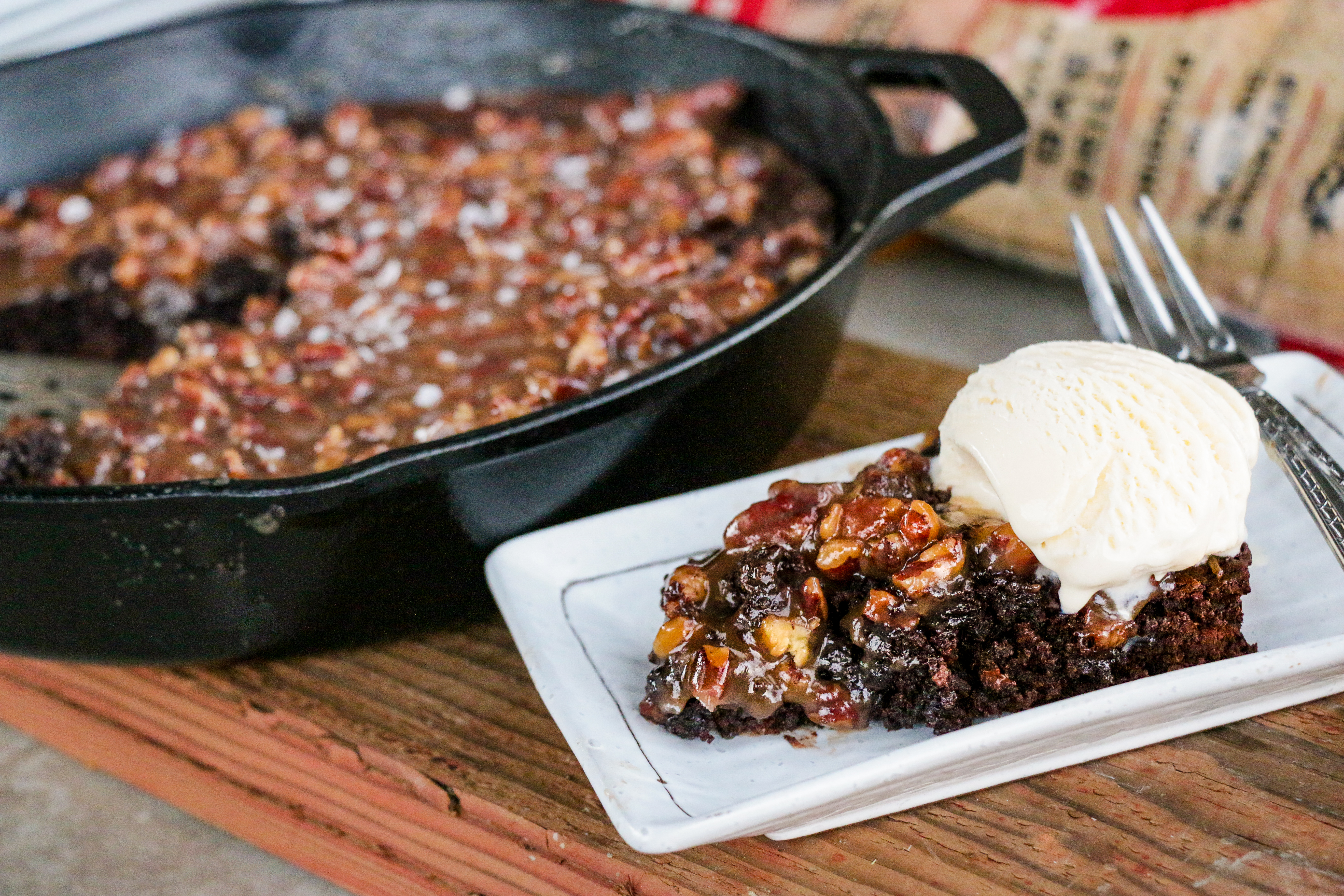 A cherry smoked brownie topped with caramel sauce and vanilla ice cream.