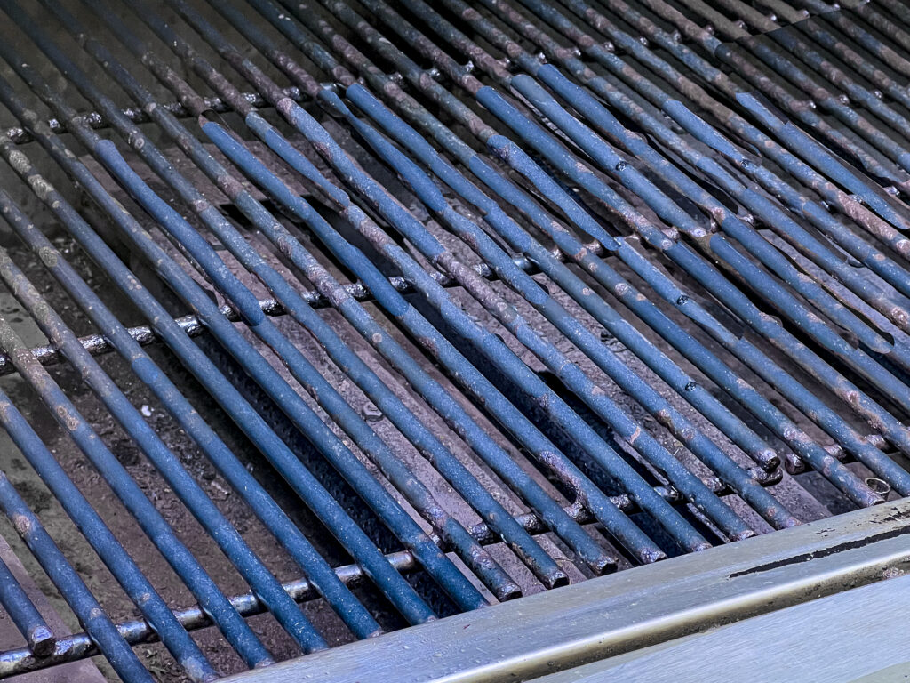 A close up of a grill grate that has been cleaned. No how much scrubbing grill grates can still have pitting.