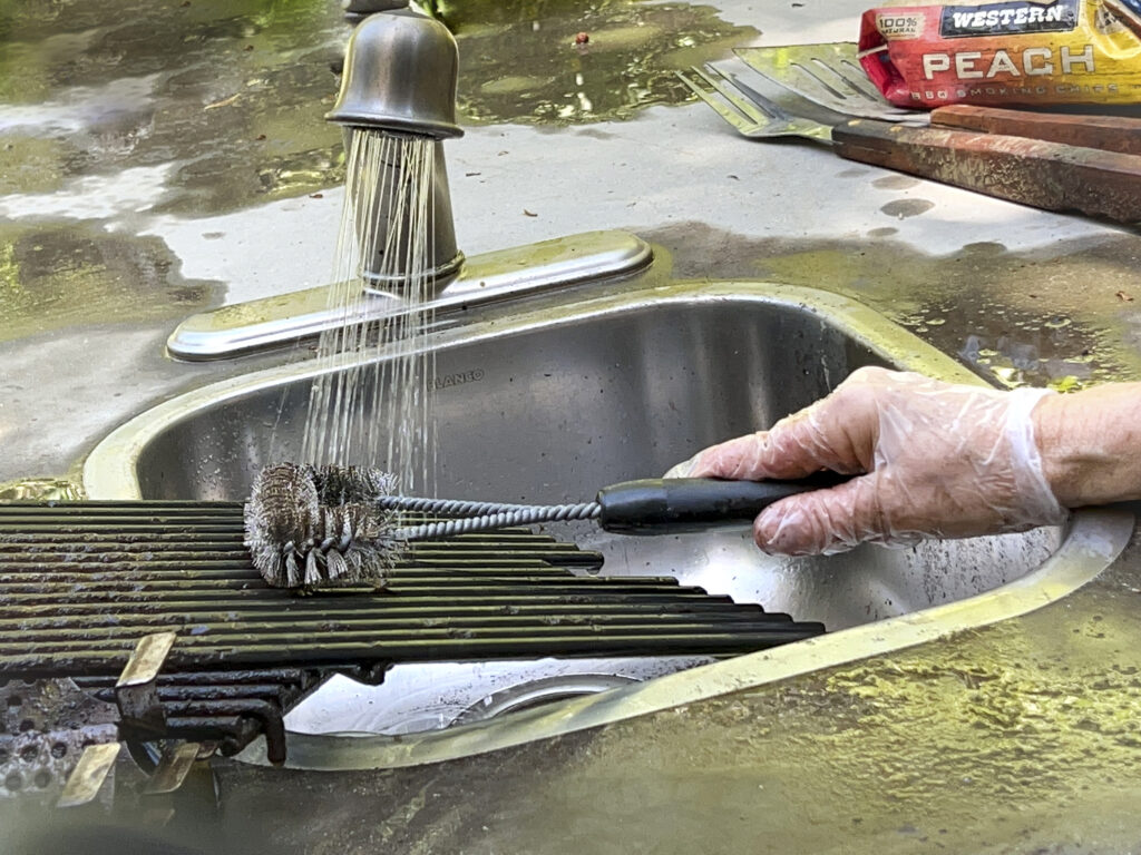 A wire brush is being used to clean grill grates.