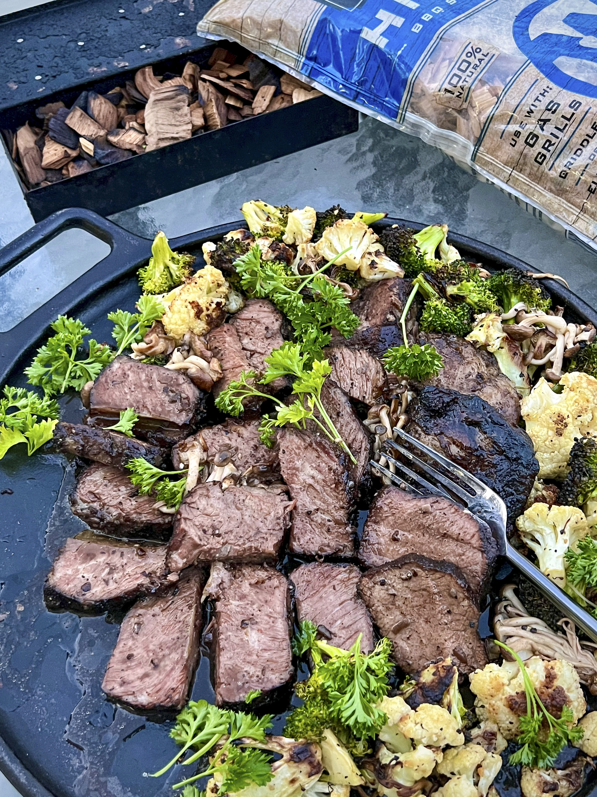 Smoked Beef Short Ribs are served on cast iron platter with cauliflower and parsley. 
