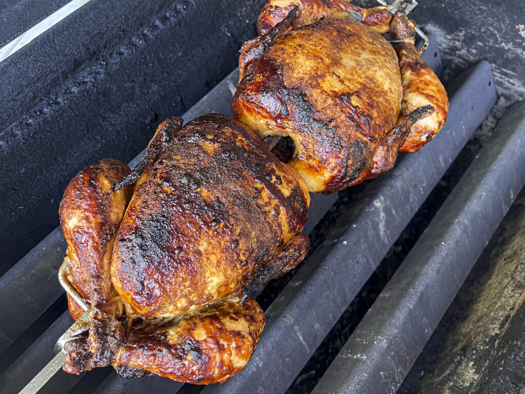 Crispy Chicken Skin is shown on two chickens still on the grill. 