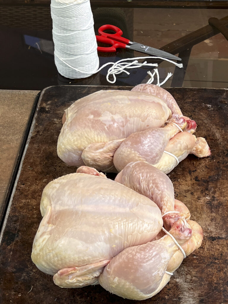 Two chickens ready to be tied up with butcher string for the rotisserie. 