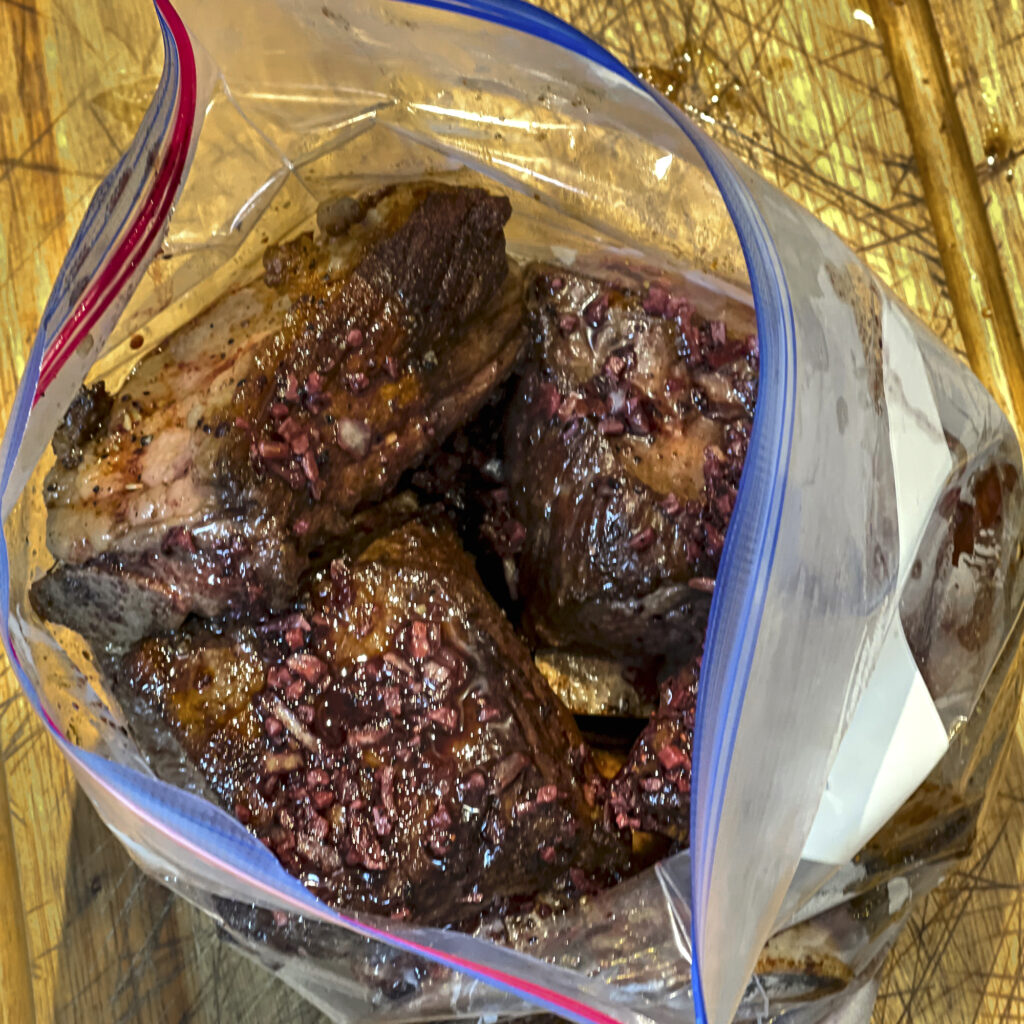 Short Ribs that have a toasted onion and red win marinade are in a plastic bag that was used for sous vide. 