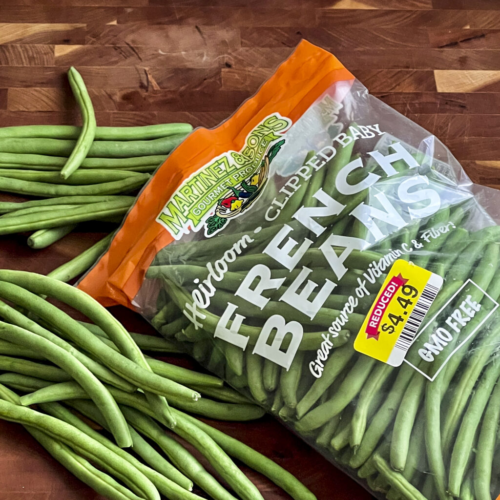 A bag of French Green Beans is on a cutting board.
