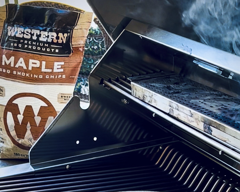 A bag of Maple Smoking Chips is near a grill. 