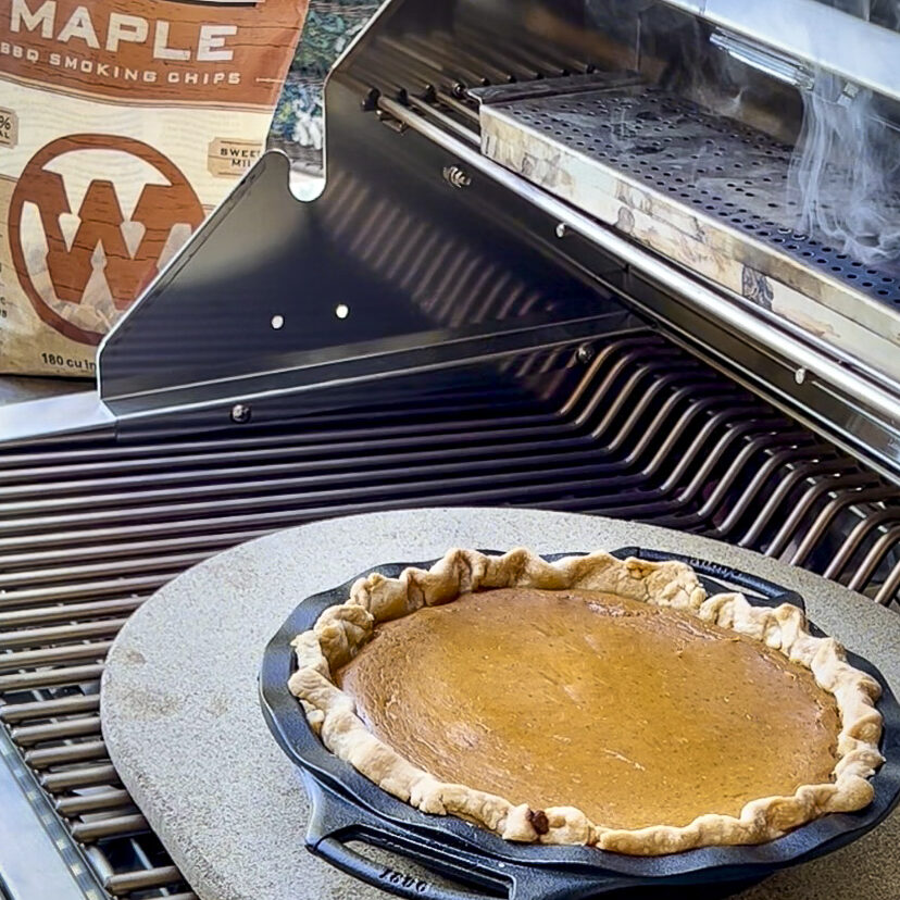 A pumpkin pie is on the grill being smoked.