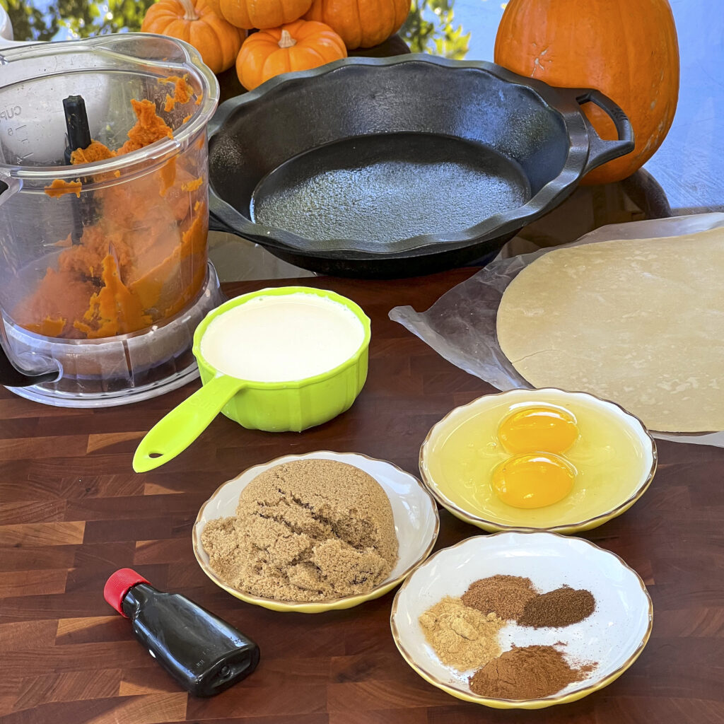 A cutting board holes pumpkin puree, brownsugar, eggs, spices, and vanilla.