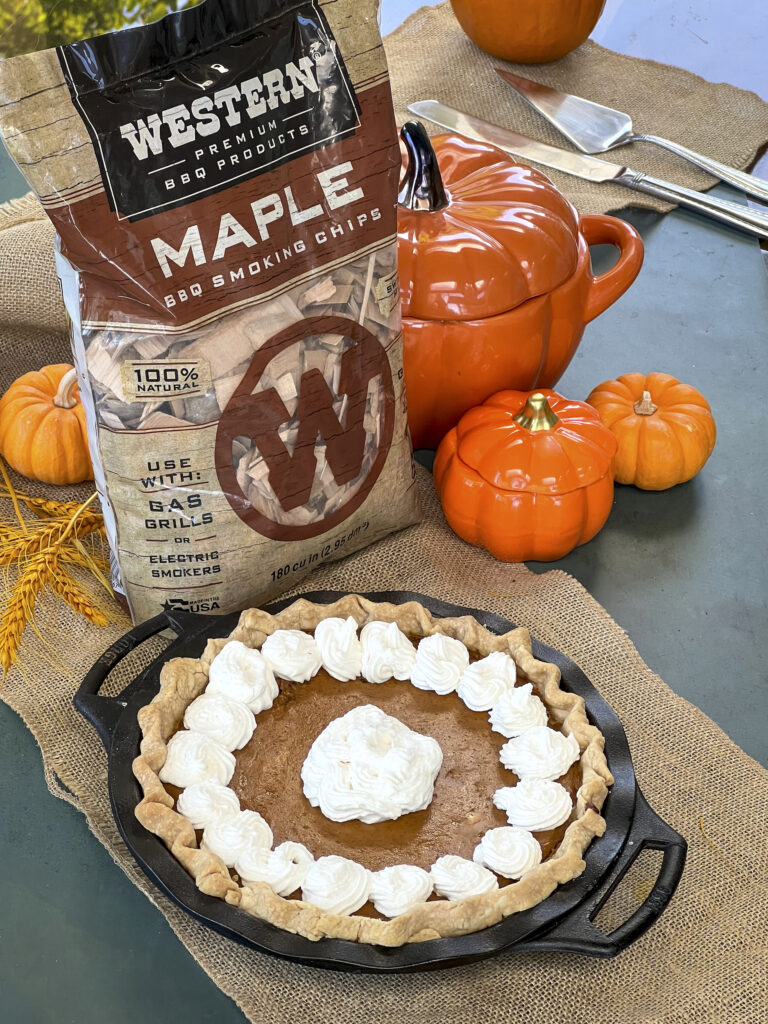 Western BBQ Maple Chips bag is next to a pumpkin pie in a cast iron skillet to show the pie has been smoked.