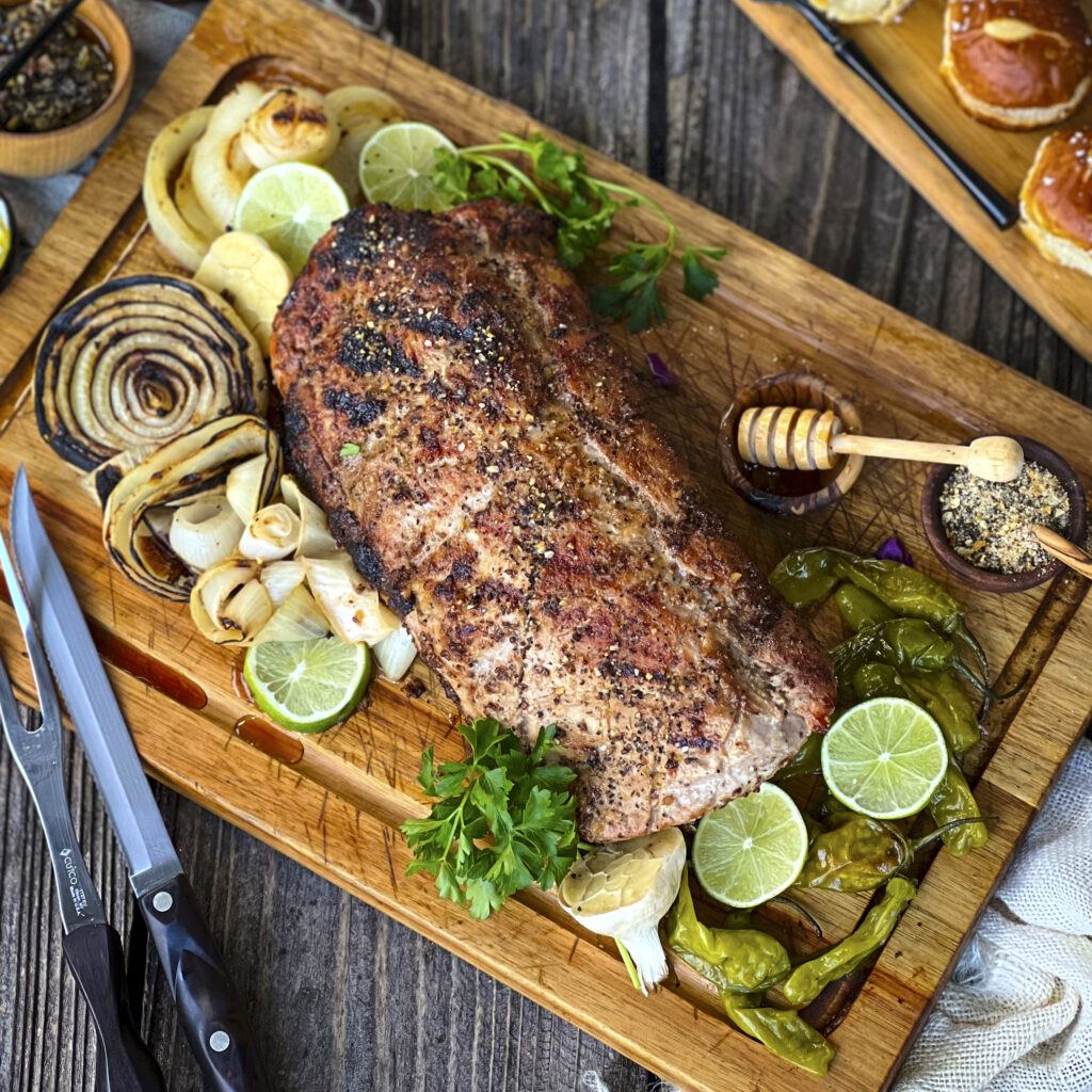 A smoked pork loin rests on a cutting board