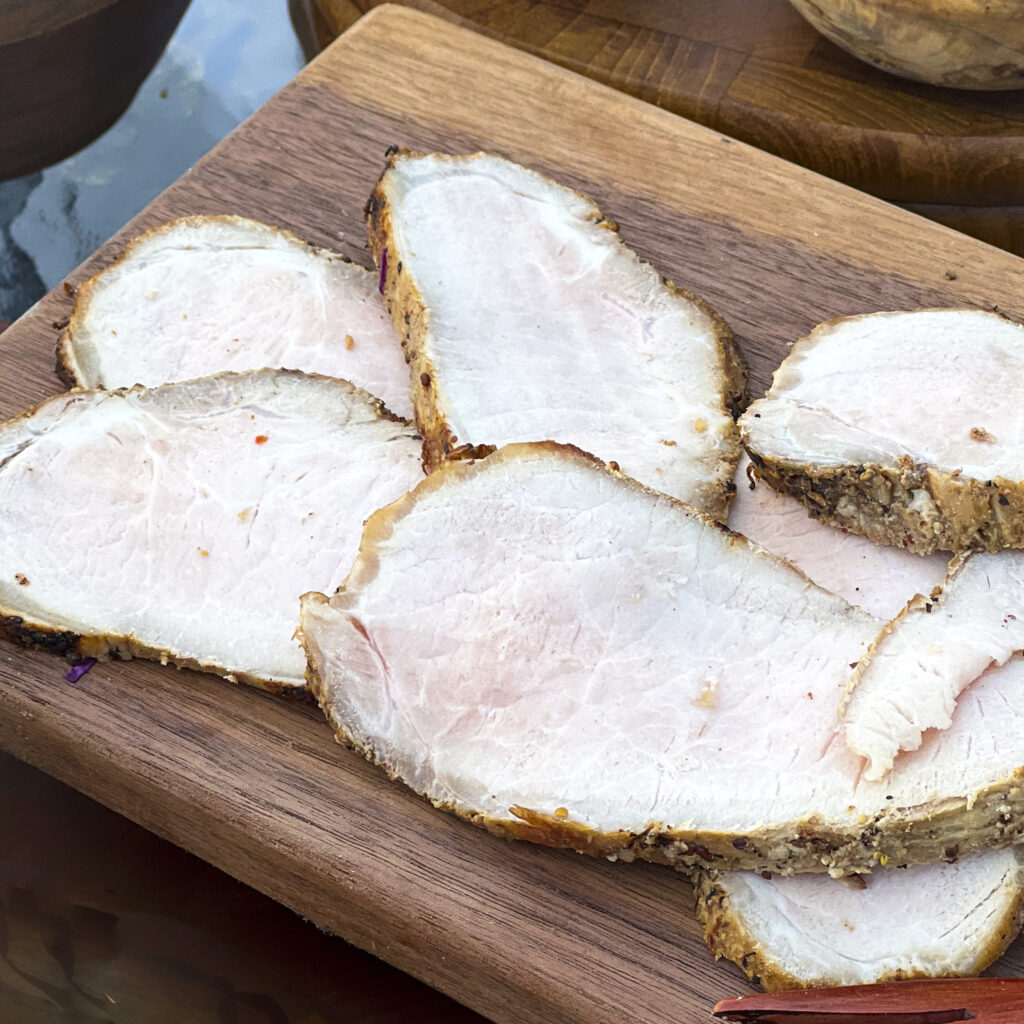 A board with slices of smoked pork loin. 