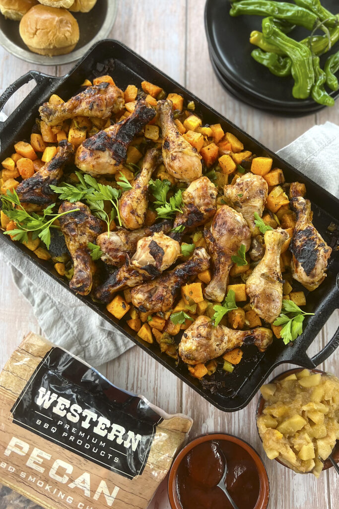 Western Pecan smoking chips are next to a platter of smoked drumsticks. 