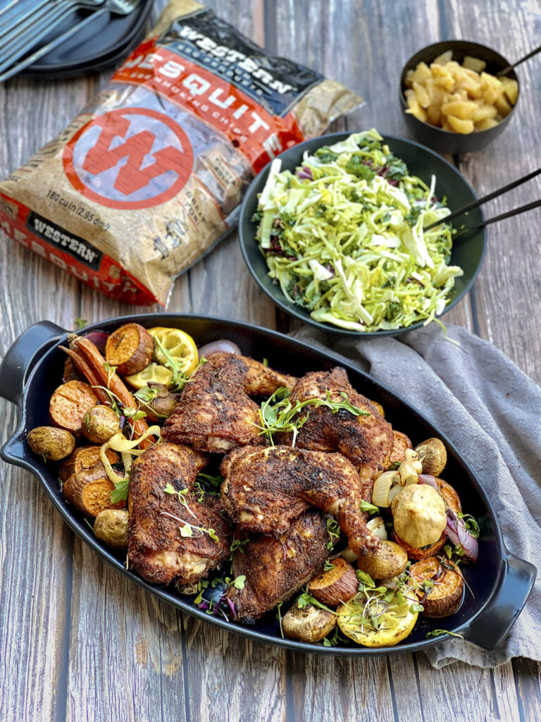 A bag of Western Mesquite Smoking chips are in a scene with smoked chicken leg quarters and salad. 