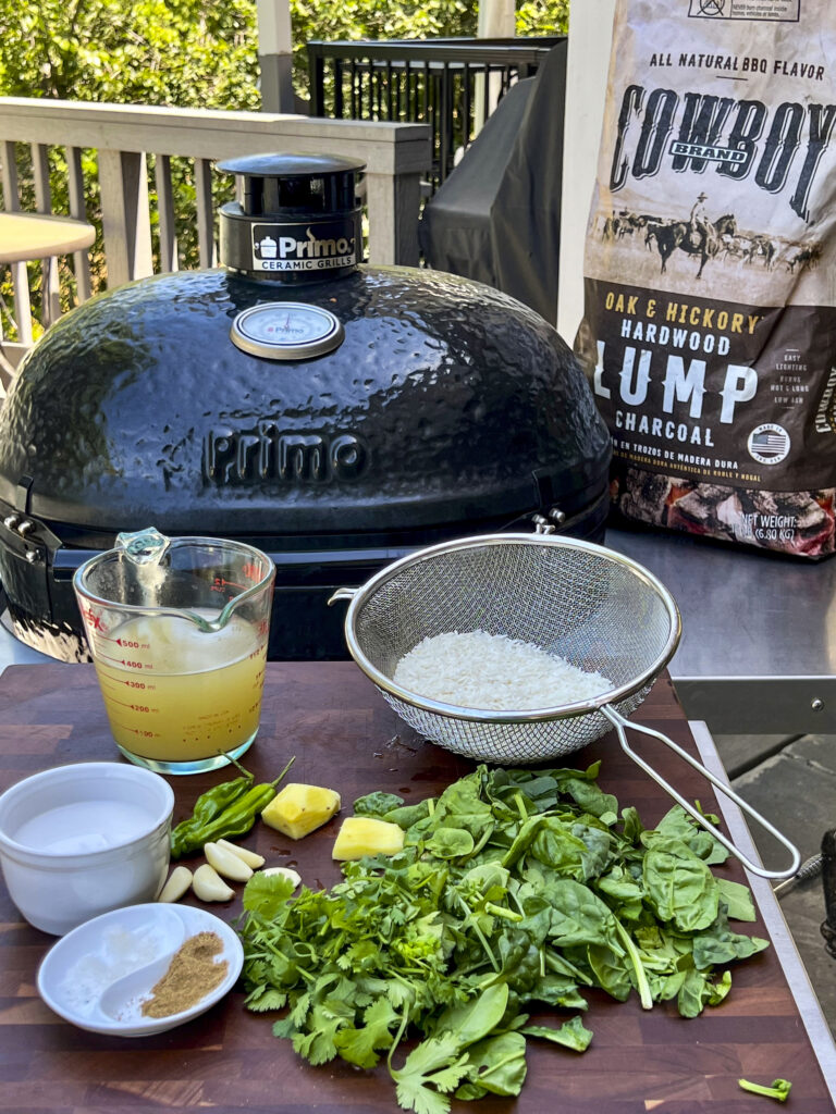 A scene with Cowboy Charcoal, a grill, and ingredients to make Smoked Hawaiian Rice. 
