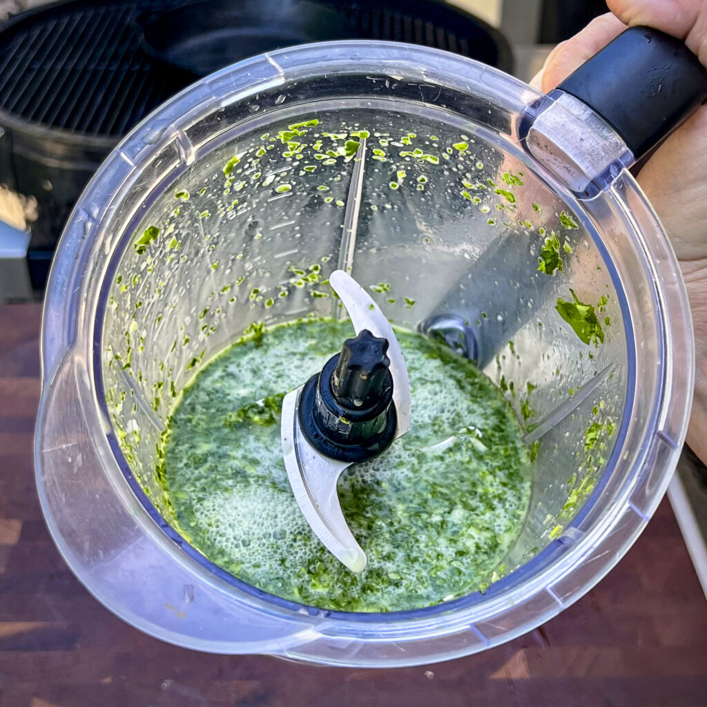 A green blended mixture is in the blender. 