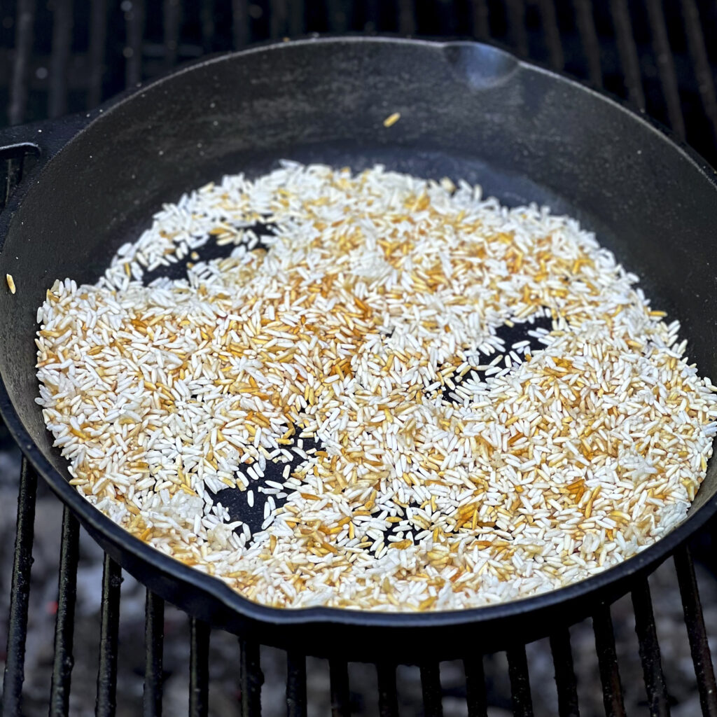 Smoked Rice has turned golden brown in a cast iron skillet. 