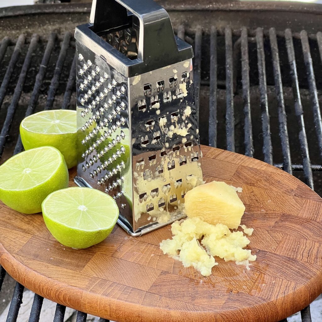 Ginger, limes and a grater on a grill. 