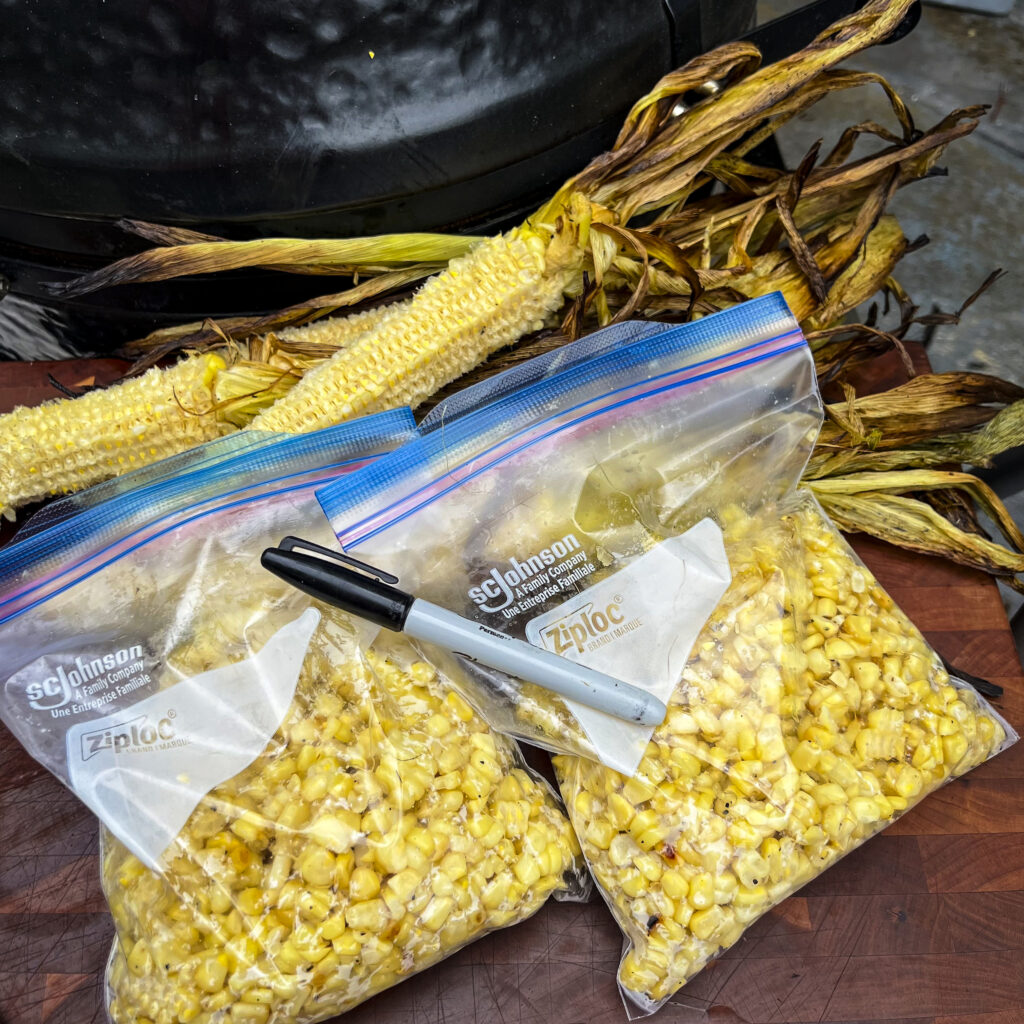 Two bags of corn kernels are ready for the freezer. 