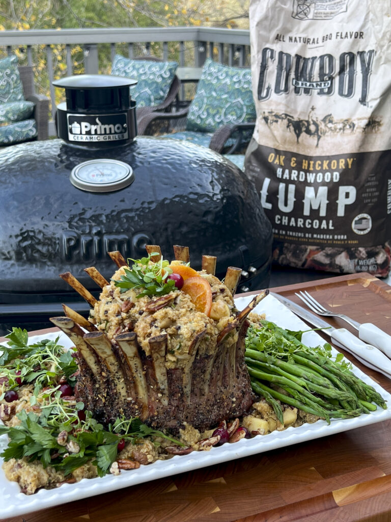 A Smoked Crown of Lamb in front of the Primo Grill with a bag of Cowboy Lump Charcoal. 