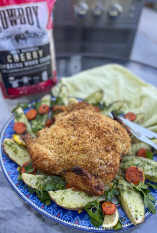 A Parmesan pinko crusted whole chicken sits on a platter for dinner.