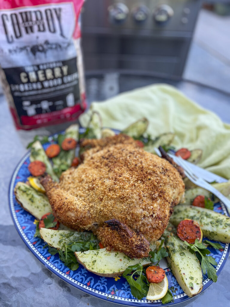 A Parmesan pinko crusted whole chicken sits on a platter for dinner.
