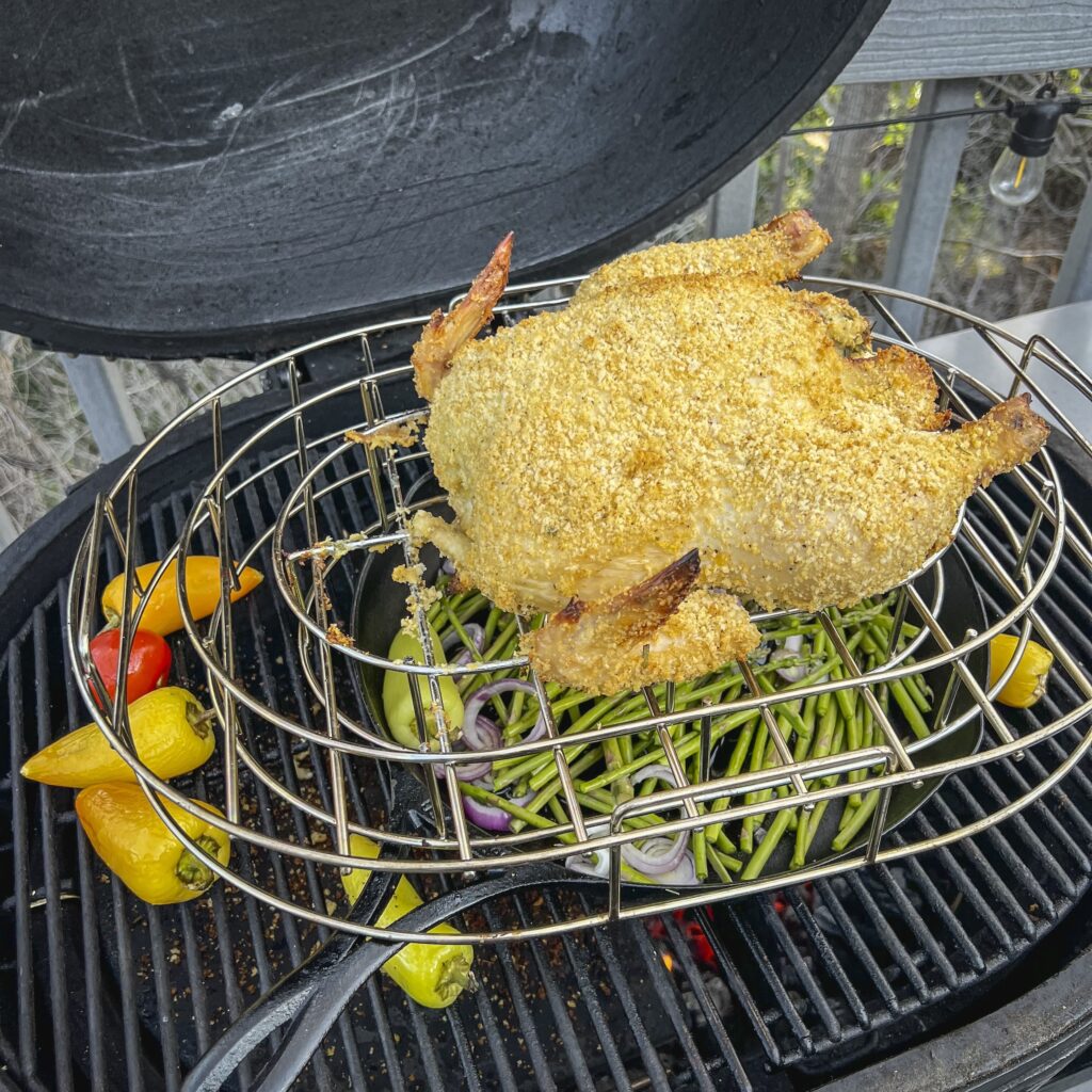 A panko crusted chicken is cooking in a kamado-style smoker.