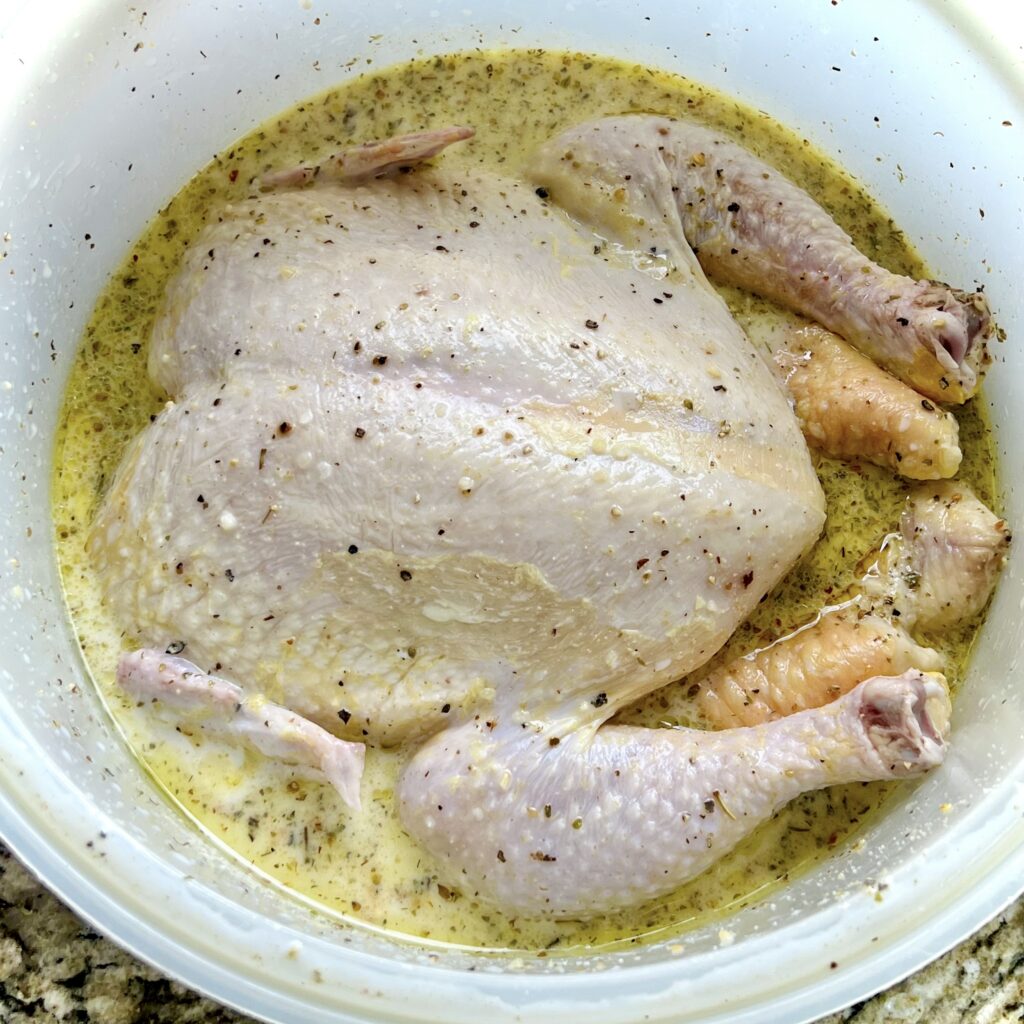 A whole chicken sits in brine. 