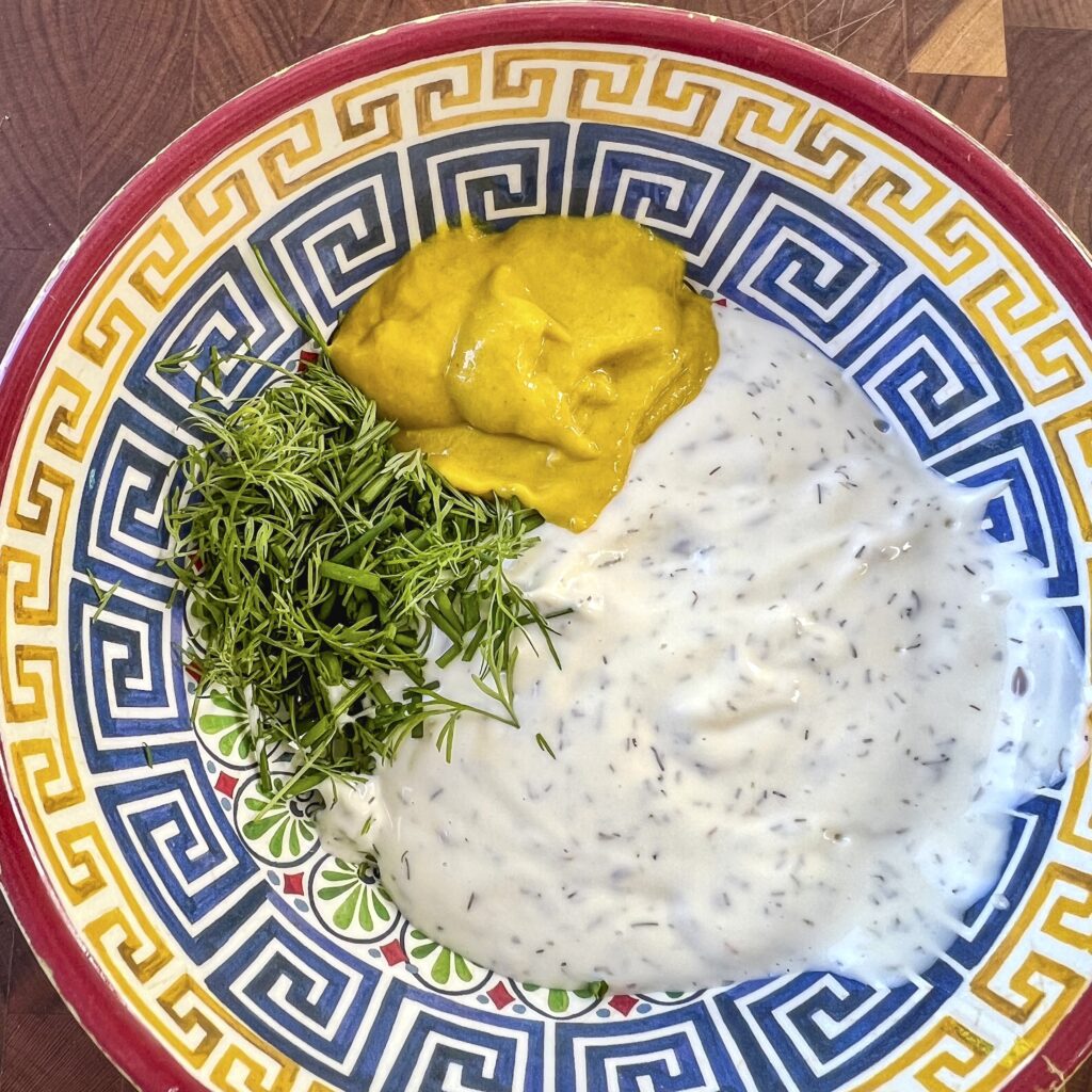 A bowl with Mustard Dill Cream Sauce ingredients.