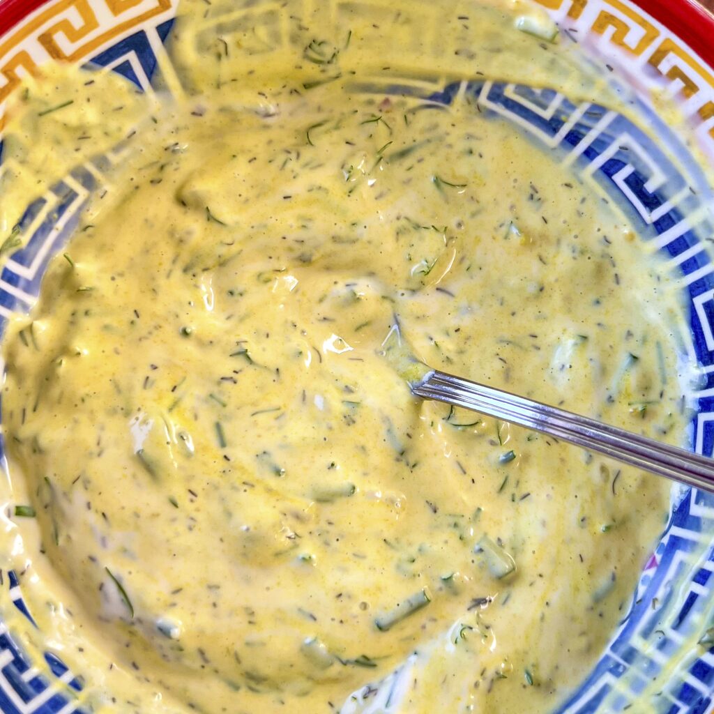 A bowl of Mustard Dill Cream Sauce is ready to be served with Smoked Trout. 