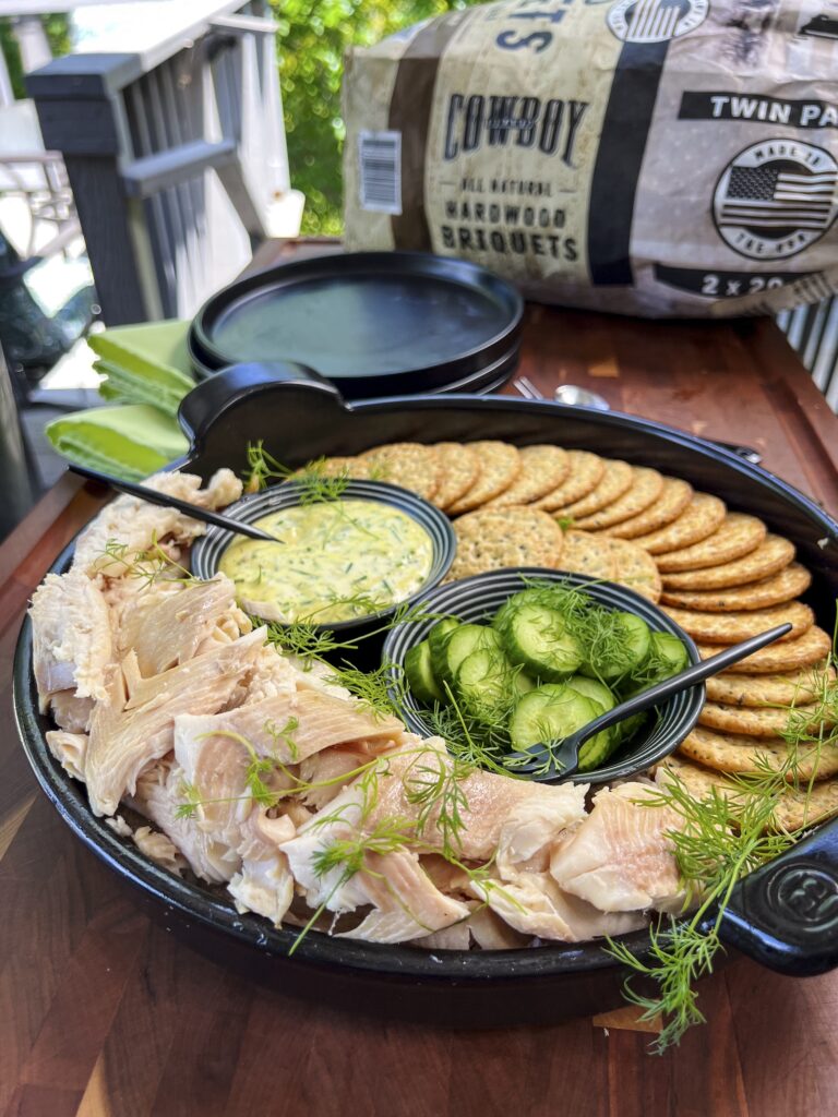 Smoked Trout is plated with mustard sauce and cucumbers with dill.